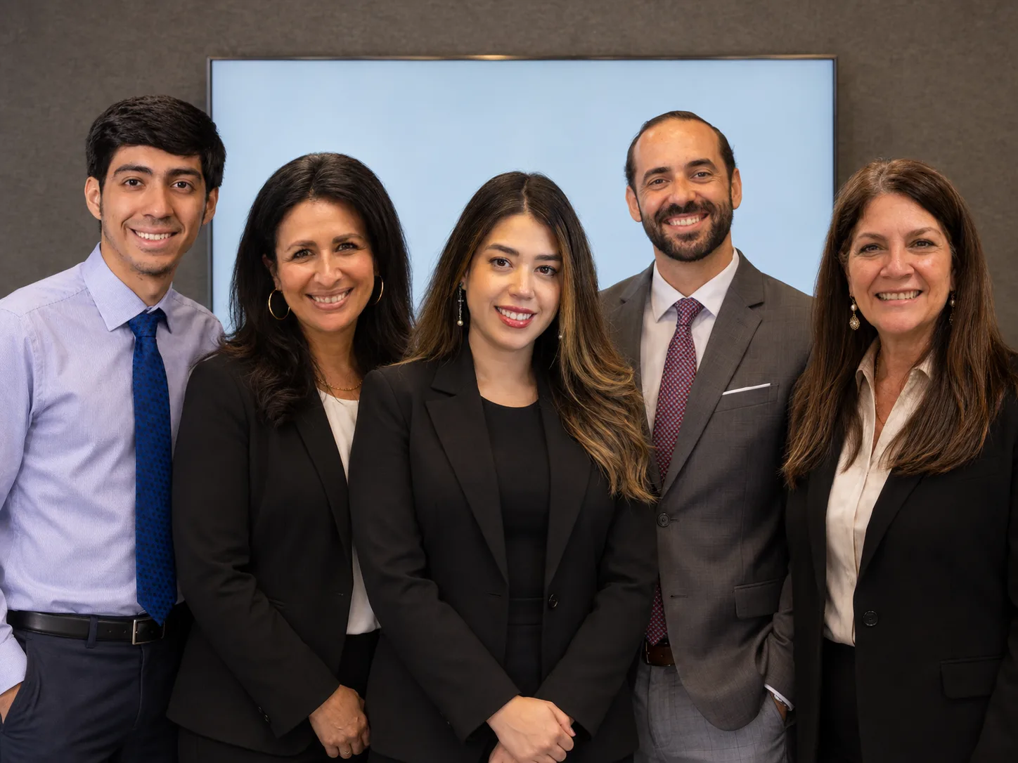 The five people of Pino Law standing together in the Orlando office.